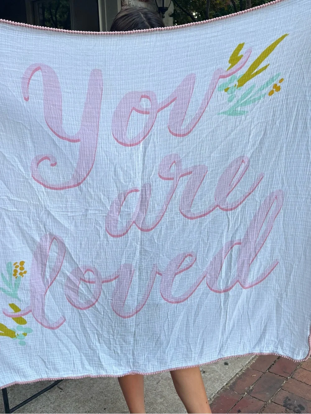 You Are Loved Pink Script Muslin Baby Blanket has a light stain